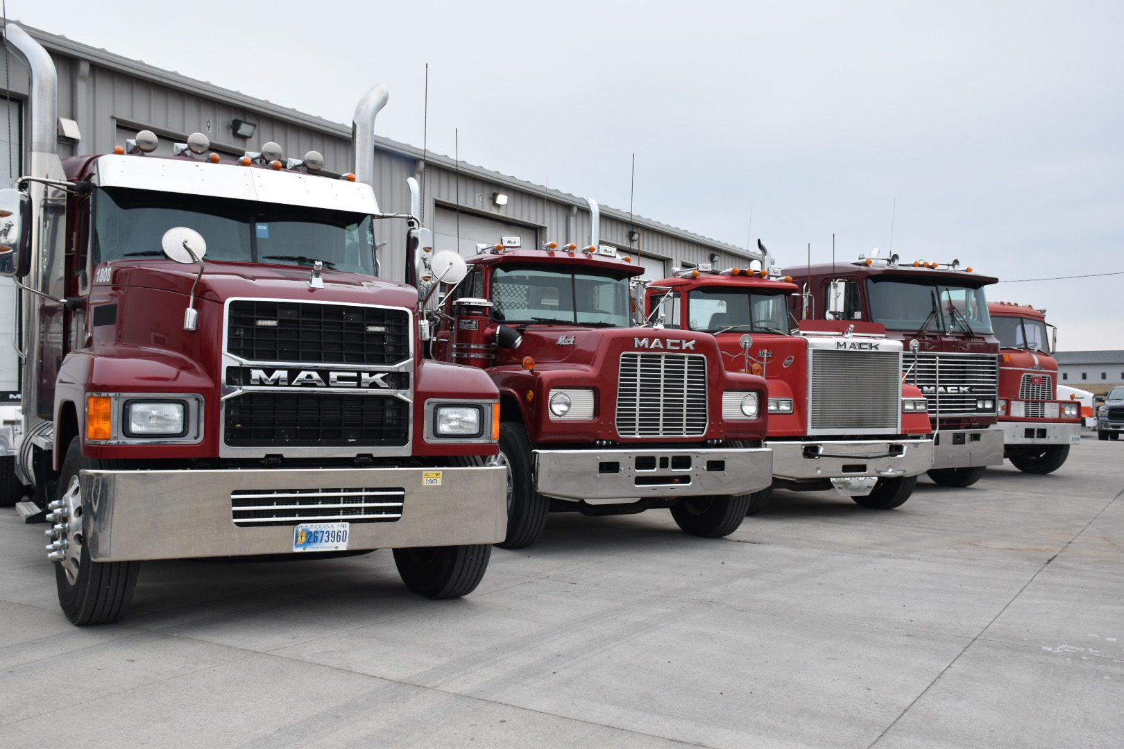 A row of red trucks parked in front of a building.