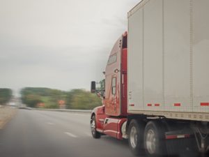 A red and white truck driving down the road.