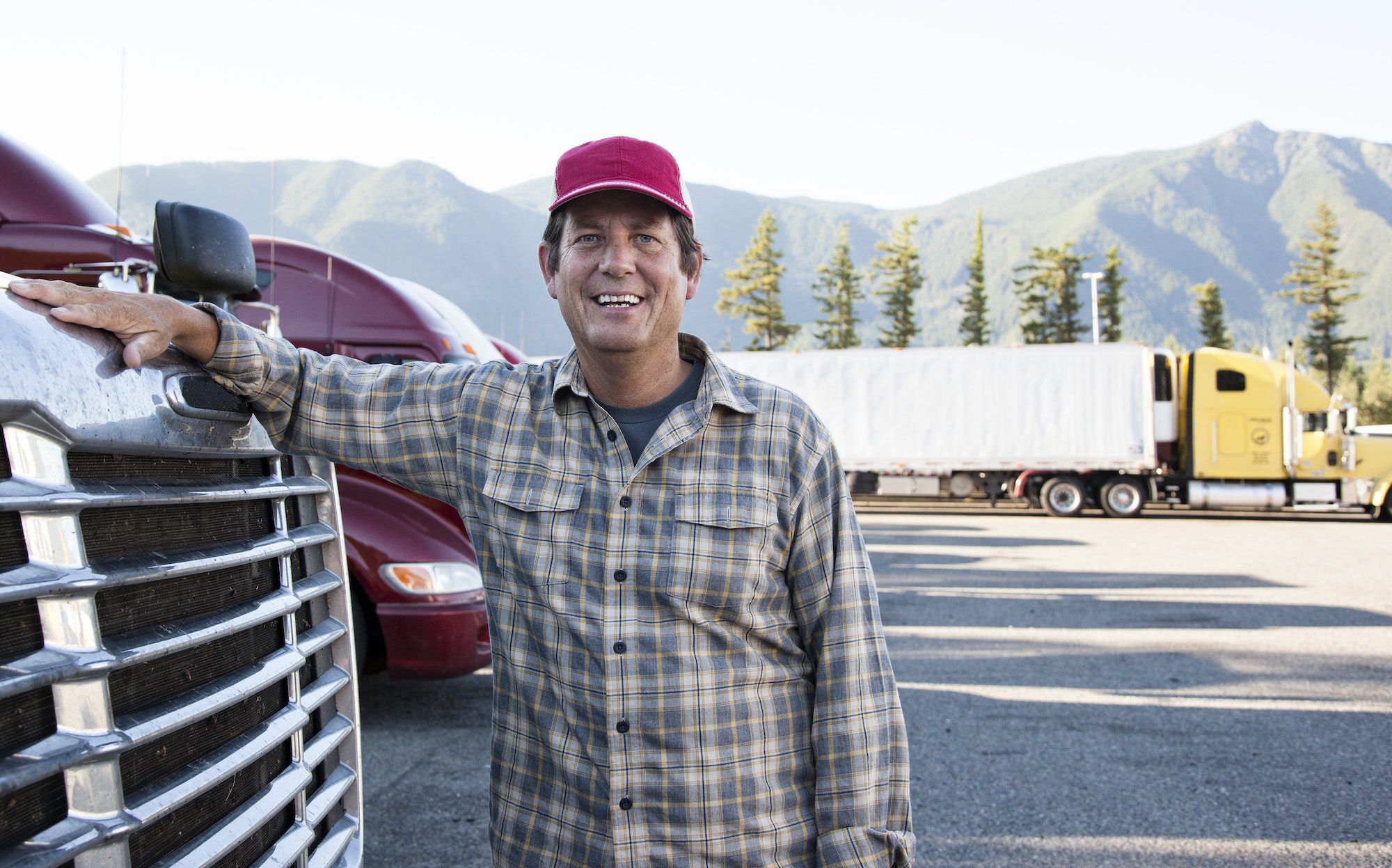 A man standing next to a truck in the parking lot.