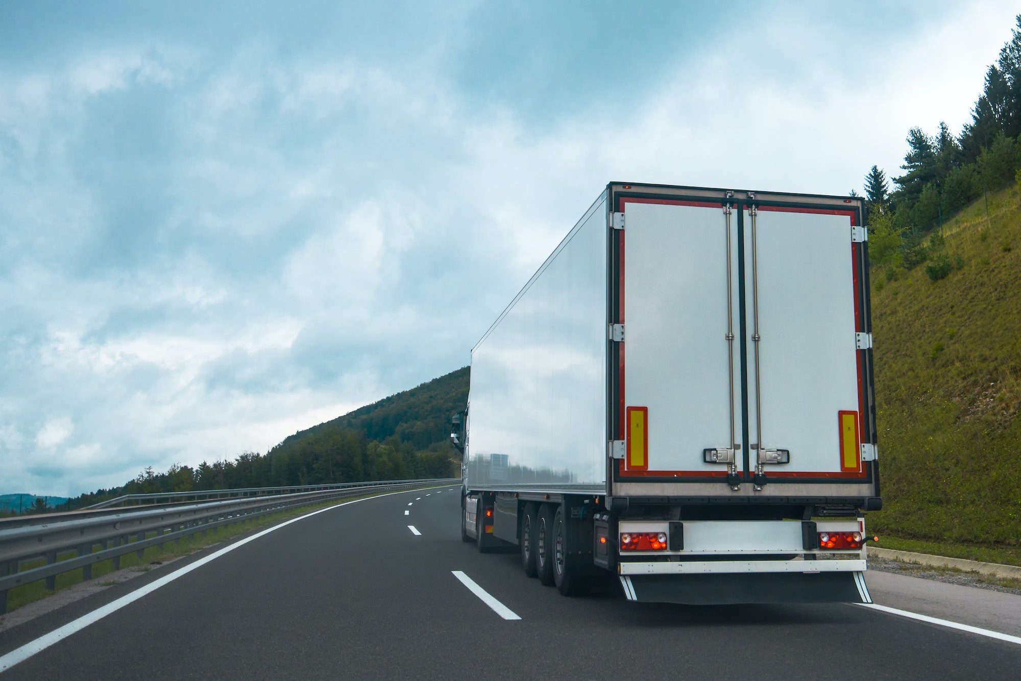 A white truck is driving down the road